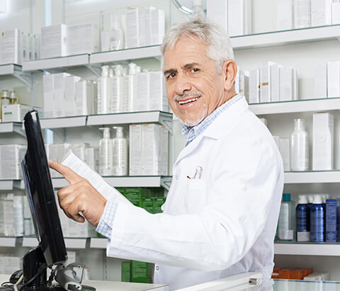 a man in a white coat preparing customer orders in a pharmacy