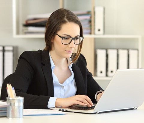 a female employee in a business outfit working on her computer
